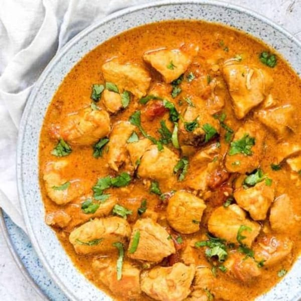 Close-up of a bowl of Indian chicken curry, garnished with fresh cilantro, from Biryani Pot.